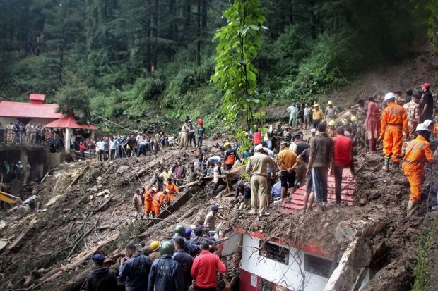 TOPSHOT - National Disaster Response Force (NDRF) personnel search for victims at the site of a landslide after a temple collapsed due to heavy rains in Shimla on August 14, 2023. At least 24 people were killed, nine of them in a temple collapse, and dozens more were feared missing after intense rains caused floods and landslides in India, officials said August 14. (Photo by AFP) (Photo by -/AFP via Getty Images)