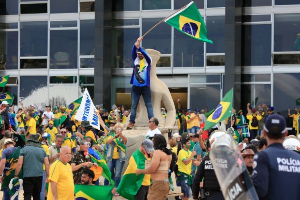 TOPSHOT - Supporters of Brazilian former President Jair Bolsonaro invade Planalto Presidential Palace while clashing with security forces in Brasilia on January 8, 2023. - Hundreds of supporters of Brazil's far-right ex-president Jair Bolsonaro broke through police barricades and stormed into Congress, the presidential palace and the Supreme Court Sunday, in a dramatic protest against President Luiz Inacio Lula da Silva's inauguration last week. (Photo by Sergio Lima / AFP) (Photo by SERGIO LIMA/AFP via Getty Images)