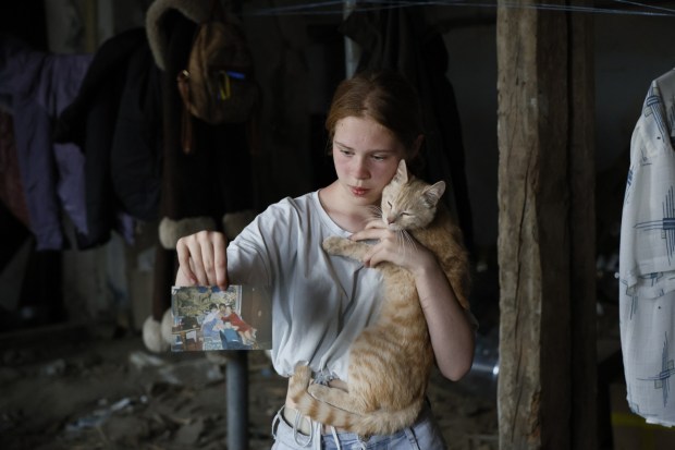 KHERSON, UKRAINE - JUNE 7: Angelina Kopayeva, 12 shows picture of her family on June 7, 2023 in Kherson, Ukraine.Early Tuesday, the Kakhovka dam and hydroelectric power plant, which sit on the Dnipro river in the southern Kherson region, were destroyed, forcing downstream communities to evacuate do to risk of flooding. The cause of the dam's collapse is not yet confirmed, with Russia and Ukraine accusing each other of its destruction. The Dnipro river has served as a frontline between the warring armies following Russia's retreat from Kherson and surrounding areas last autumn. The dam and plant had been under the control of Russia, which occupies a swath of land south and southeast of the river. (Photo by Alex Babenko/Getty Images)