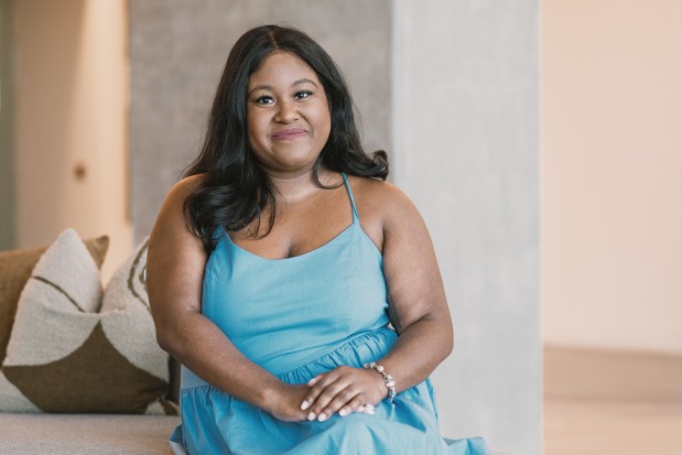 A woman in a light blue dress sits.