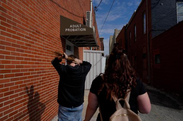 Jesse Johnson of the Family Resource Center, right, walks with client Tyler Baker to the Hancock County Adult Probation office for a random drug test in Findlay, Ohio, Thursday, Oct. 12, 2023. Earlier this year, Johnson started a job with the Family Resource Center, the same organization that employed the peer support worker who was so instrumental in her own early recovery. (AP Photo/Carolyn Kaster)