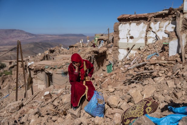 DOUZROU, MOROCCO - SEPTEMBER 11: A woman sits amongst the rubble of her village that was almost completely destroyed by Friday's earthquake, on September 11, 2023 in Douzrou, Morocco. Over 2600 people are now reported dead following the large earthquake that struck below villages in the High Atlas mountains around 70km south of Marrakesh. (Photo by Carl Court/Getty Images)