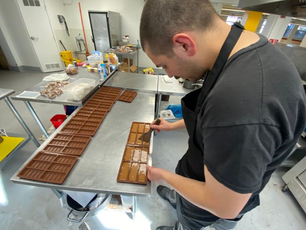 Jeff Morsfield Owner of Jeff's Candy Shop slightly separates the molds from the just poured candy before allowing them to rest. (Frank Mecham- The News-Herald.)