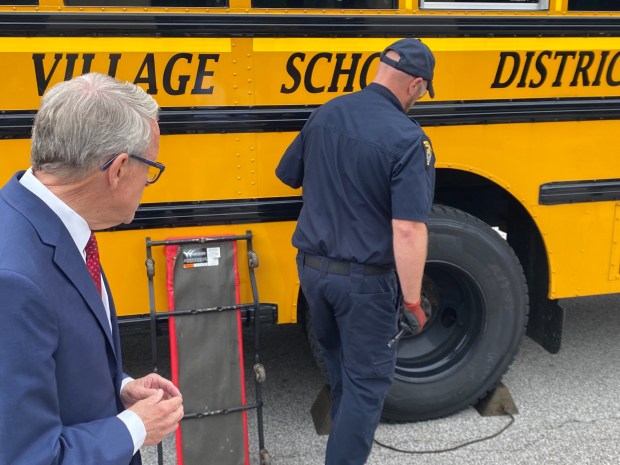 Gov. Mike DeWine watches as an inspector with the Ohio Highway Patrol shows how an inspection is carried out. (Frank Mecham- The News-Herald.)