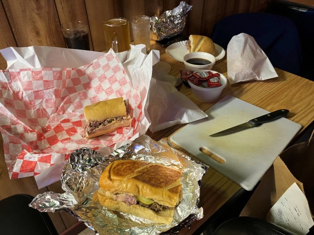 A bartender at Copper Penny in Parma provided a knife and cutting board to split up a take-out feast from nearby sandwich shop Au Jus. (Mark Meszoros - The News-Herald)